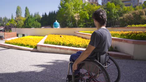 Behinderter-Junger-Mann-Sitzt-Im-Rollstuhl-Im-Park.